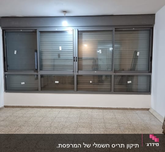 תריסים סגורים בחלון גדול עם מסגרת מתכת